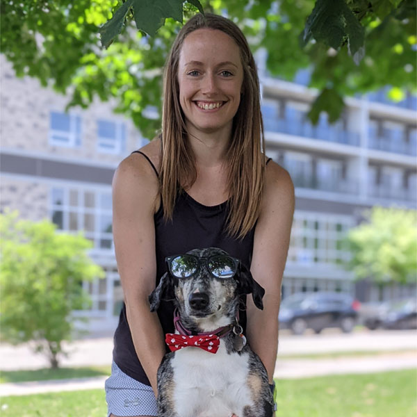 Emily smiling and holding her dog